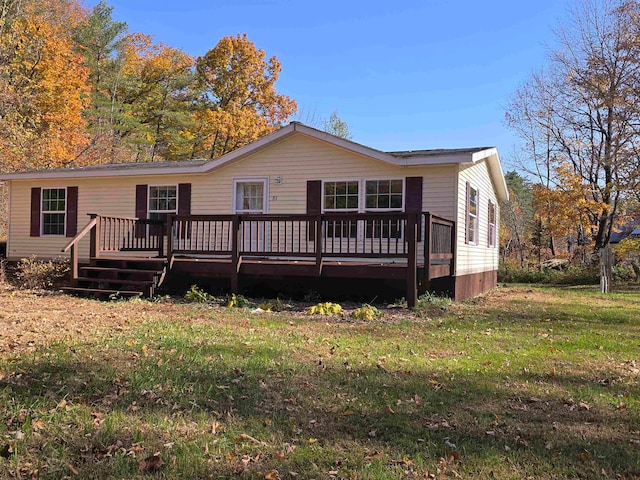 back of property with a deck and a yard