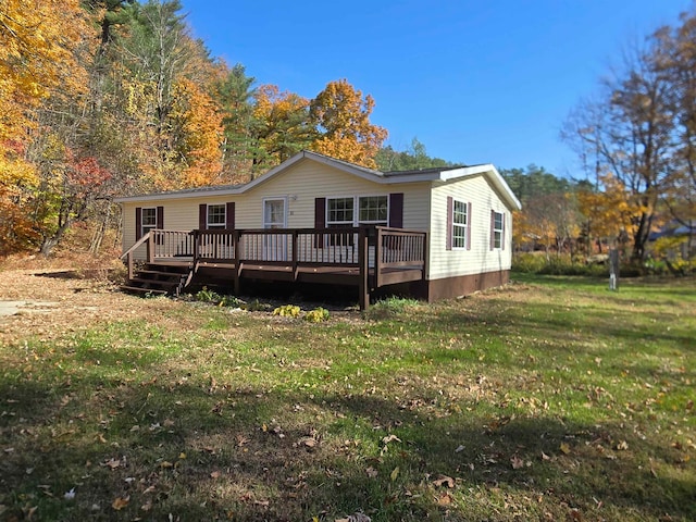 rear view of property with a deck and a lawn