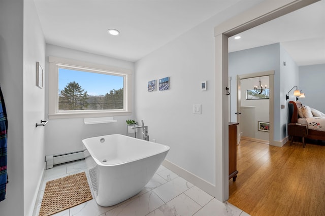 bathroom with a bathing tub and a baseboard radiator