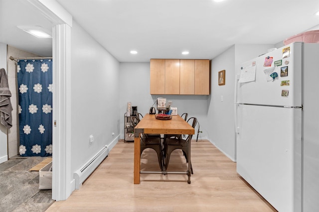 dining room with light hardwood / wood-style floors and baseboard heating