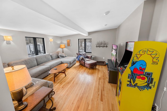 living room featuring beamed ceiling and light wood-type flooring