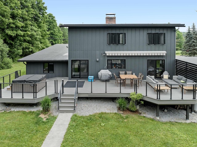 back of property featuring a wooden deck and a lawn