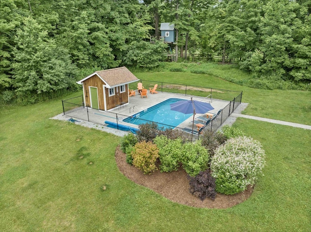 view of pool with a shed and a lawn