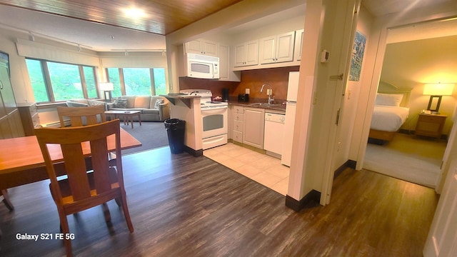 kitchen featuring white cabinets, light wood-type flooring, white appliances, and kitchen peninsula