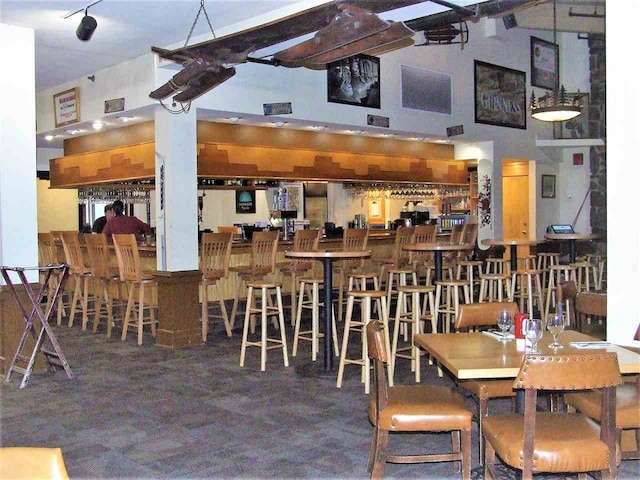 carpeted dining room with a towering ceiling