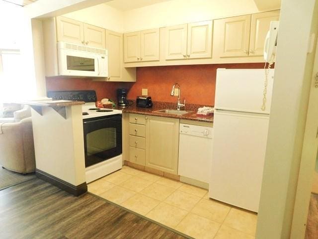 kitchen with sink, light hardwood / wood-style floors, and white appliances