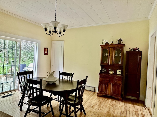 dining room with a notable chandelier, ornamental molding, light hardwood / wood-style floors, and a baseboard heating unit