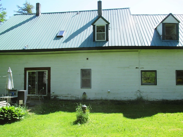 back of house featuring a lawn and a patio area