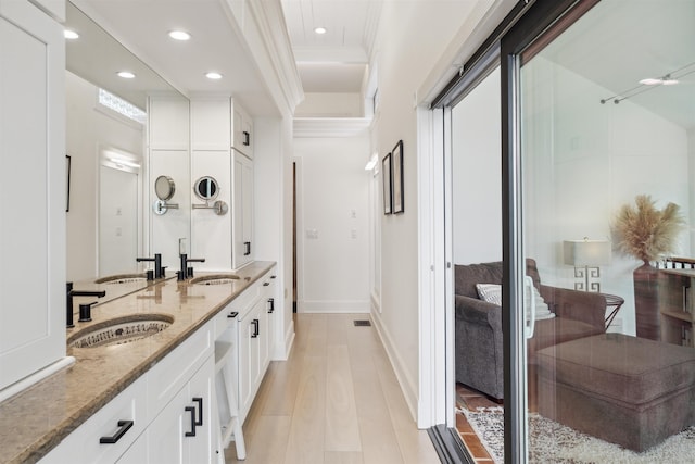 bathroom featuring wood-type flooring, vanity, and crown molding