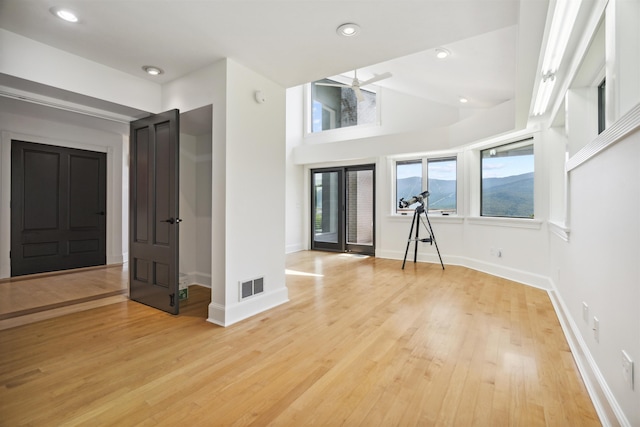 foyer featuring ceiling fan, lofted ceiling, and light wood-type flooring