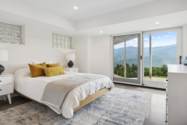 bedroom featuring a mountain view, access to outside, and multiple windows