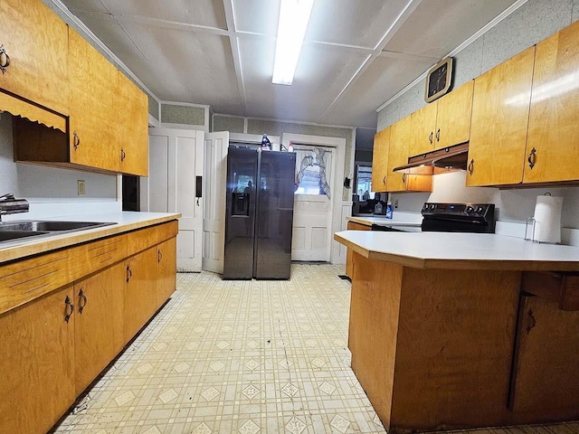 kitchen with light floors, light countertops, black fridge with ice dispenser, electric range, and under cabinet range hood