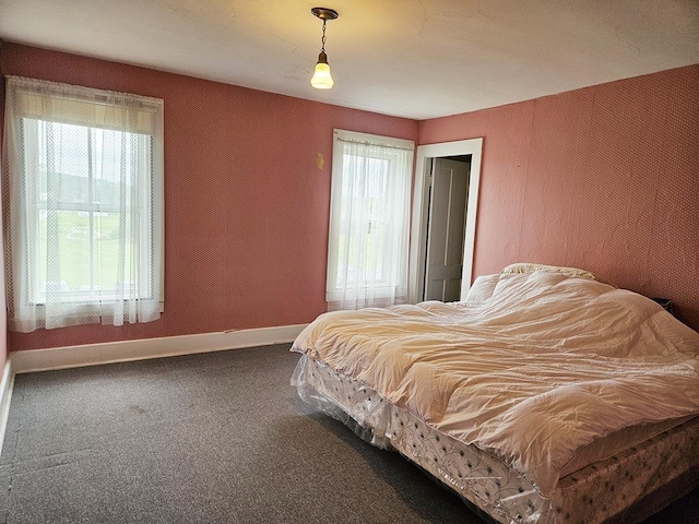 bedroom featuring carpet floors, multiple windows, and baseboards