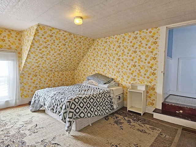 bedroom with wallpapered walls, baseboards, and wood finished floors