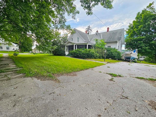 view of front of home with aphalt driveway and a front yard