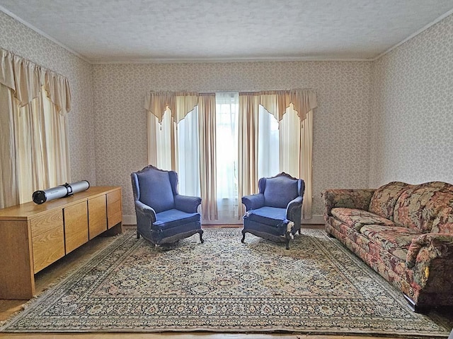 living room featuring crown molding, a textured ceiling, and wallpapered walls