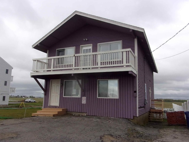 view of front facade featuring board and batten siding and a balcony