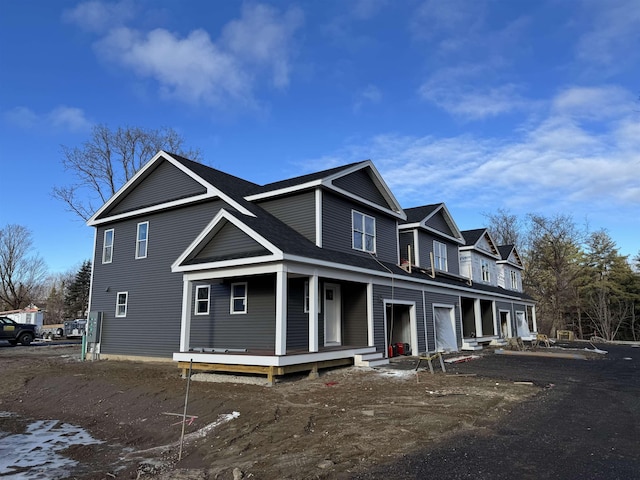 exterior space with roof with shingles and a porch