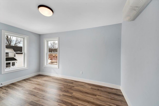 unfurnished room featuring baseboards and wood finished floors