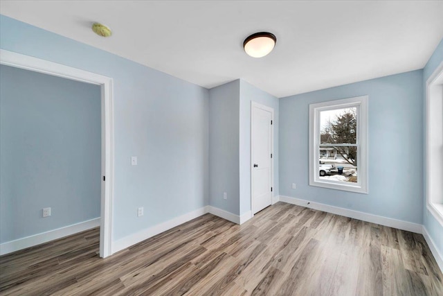 unfurnished room featuring wood finished floors and baseboards