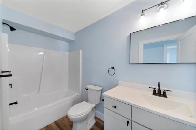 full bathroom featuring vanity, toilet, wood finished floors, and shower / washtub combination