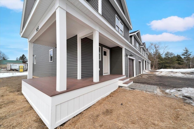 view of side of property featuring a garage and covered porch