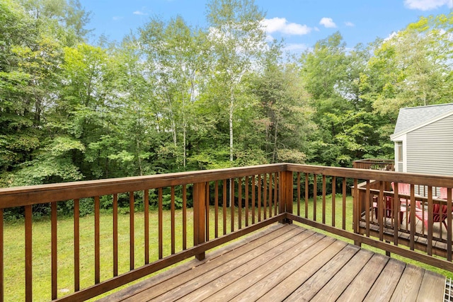 wooden terrace featuring a lawn