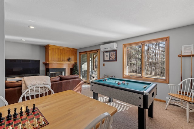 rec room featuring a wealth of natural light, a large fireplace, light colored carpet, and a wall mounted AC