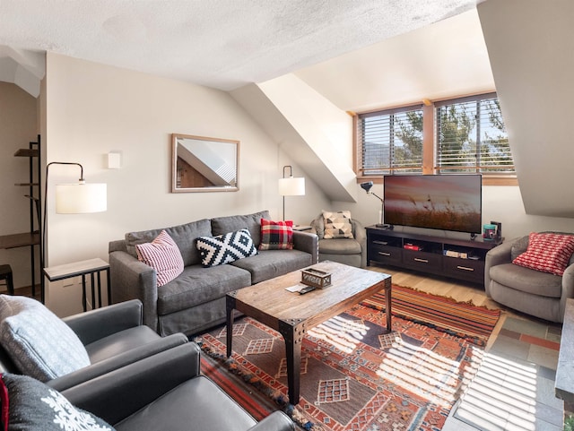 living room with a textured ceiling and lofted ceiling