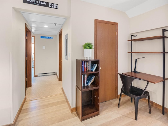 hallway with baseboard heating and light hardwood / wood-style flooring