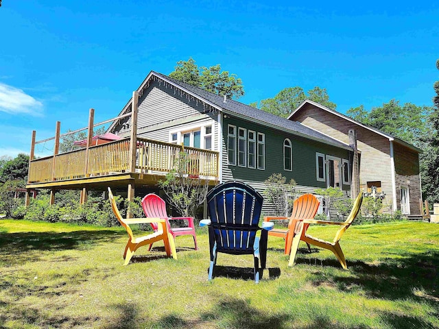 back of house with a deck and a lawn