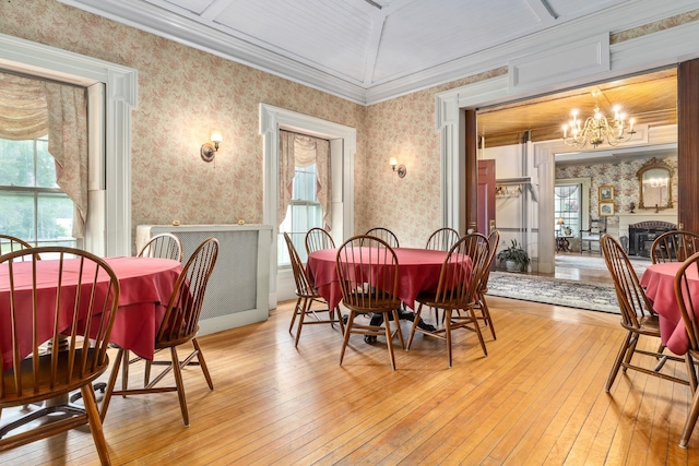 dining area featuring crown molding, an inviting chandelier, and light wood-type flooring