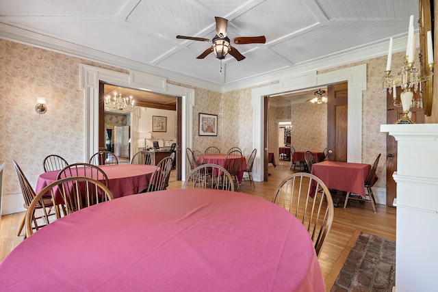 dining area featuring hardwood / wood-style flooring, crown molding, coffered ceiling, and ceiling fan with notable chandelier