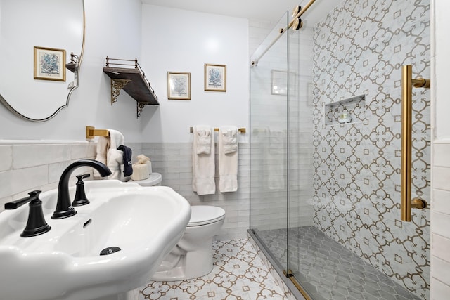 bathroom featuring sink, tile walls, tile patterned flooring, an enclosed shower, and toilet