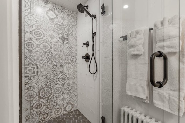 bathroom featuring radiator and a shower with shower door