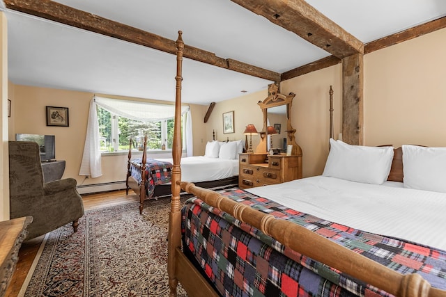 bedroom featuring a baseboard heating unit, hardwood / wood-style floors, and beamed ceiling