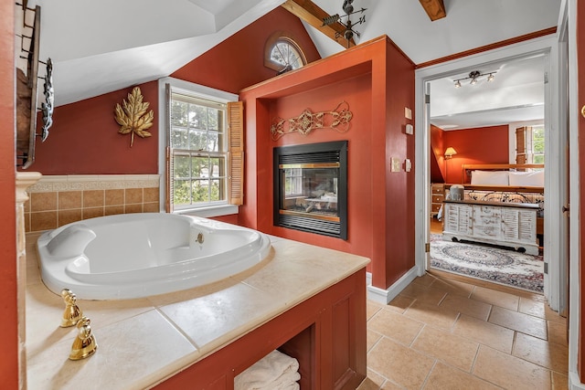 bathroom with a relaxing tiled tub, lofted ceiling, and a wealth of natural light