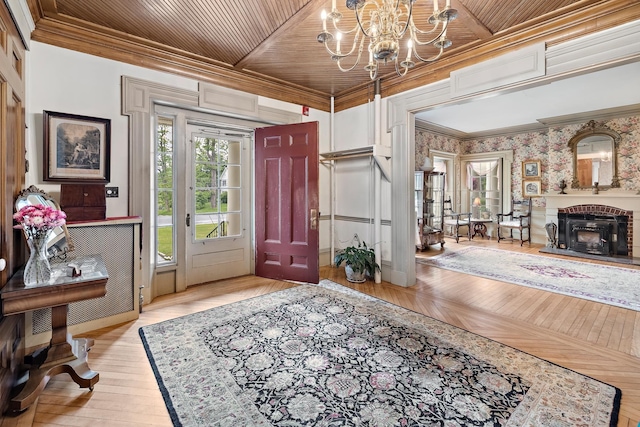 foyer featuring ornamental molding, wooden ceiling, an inviting chandelier, and light hardwood / wood-style flooring