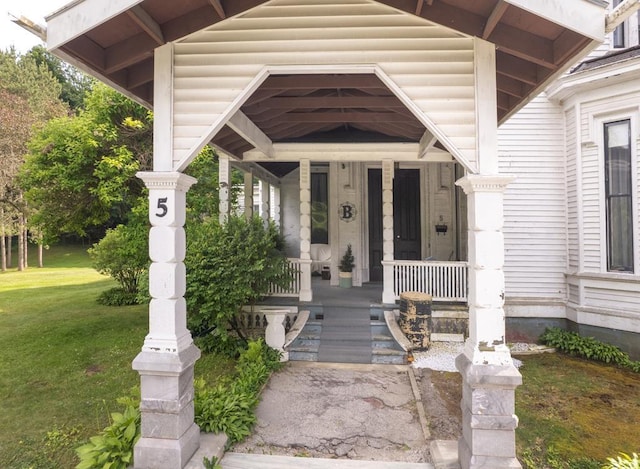 property entrance featuring a porch and a lawn