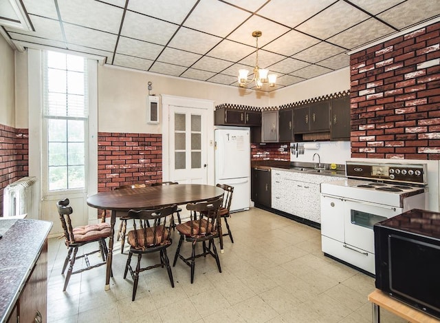 kitchen with an inviting chandelier, brick wall, white refrigerator, dark brown cabinets, and range