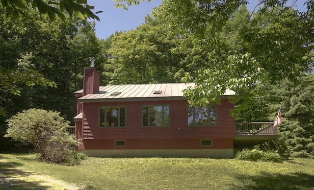 back of property featuring a wooden deck and a yard