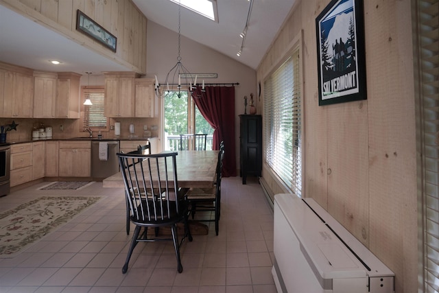 dining space featuring lofted ceiling, sink, and light tile patterned flooring