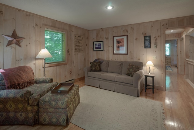 living room with wooden walls, light hardwood / wood-style floors, and baseboard heating