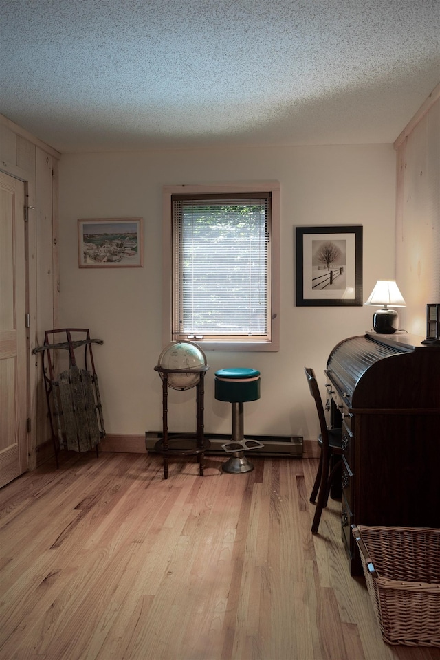 office area with light hardwood / wood-style flooring and a textured ceiling