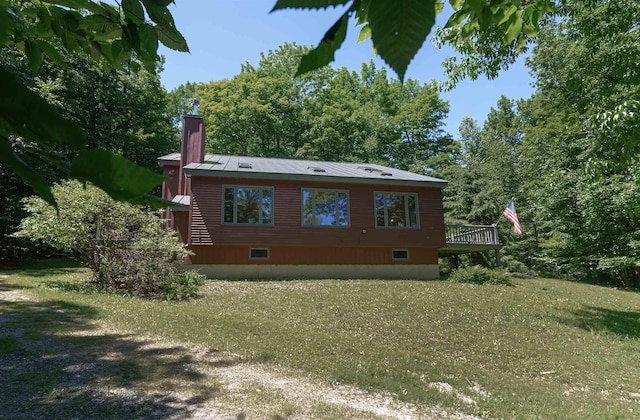 rear view of property with a deck and a lawn