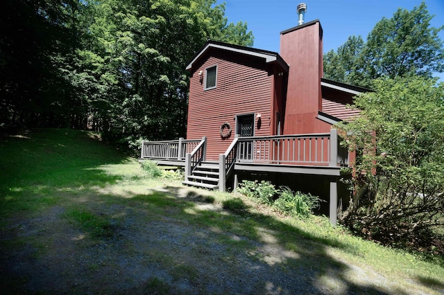 rear view of house with a wooden deck and a yard