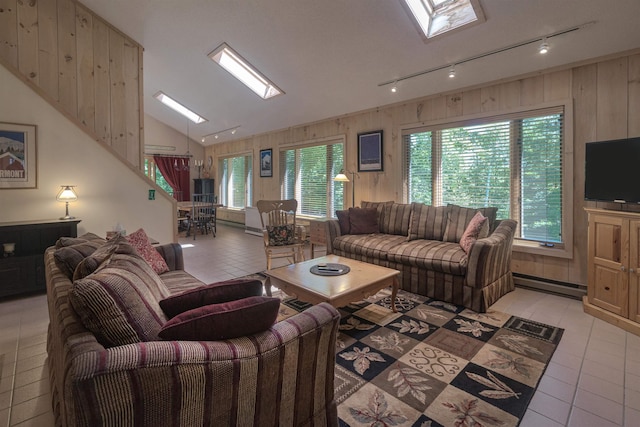 tiled living room with a baseboard radiator, lofted ceiling with skylight, and wood walls