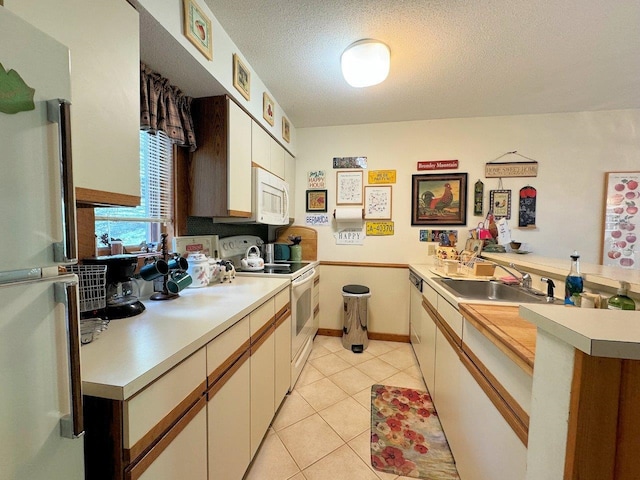 34 Sugar Brook Rd Unit F4, Peru, VT 05152 - kitchen featuring white appliances, a peninsula, a sink, light countertops, and a textured ceiling