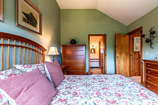 bedroom with connected bathroom and vaulted ceiling