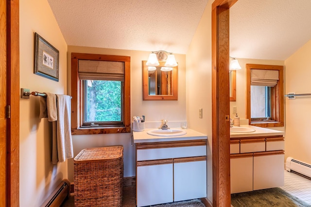 bathroom with vanity, baseboard heating, and a textured ceiling